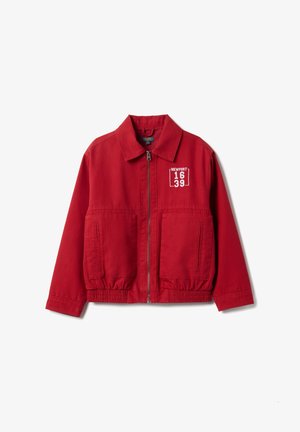 Chaqueta roja con cremallera frontal, dos bolsillos delanteros y dobladillo elástico. Lleva el texto bordado "NEWPORT 1639" en el pecho izquierdo.