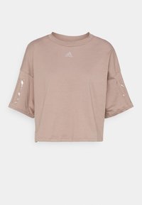 Kortärmad, cropped t-shirt i ljusbeige. Tillverkad av mjukt tyg med rund halsringning, prydd med en liten logotyp och tydliga detaljer på ärmarna.