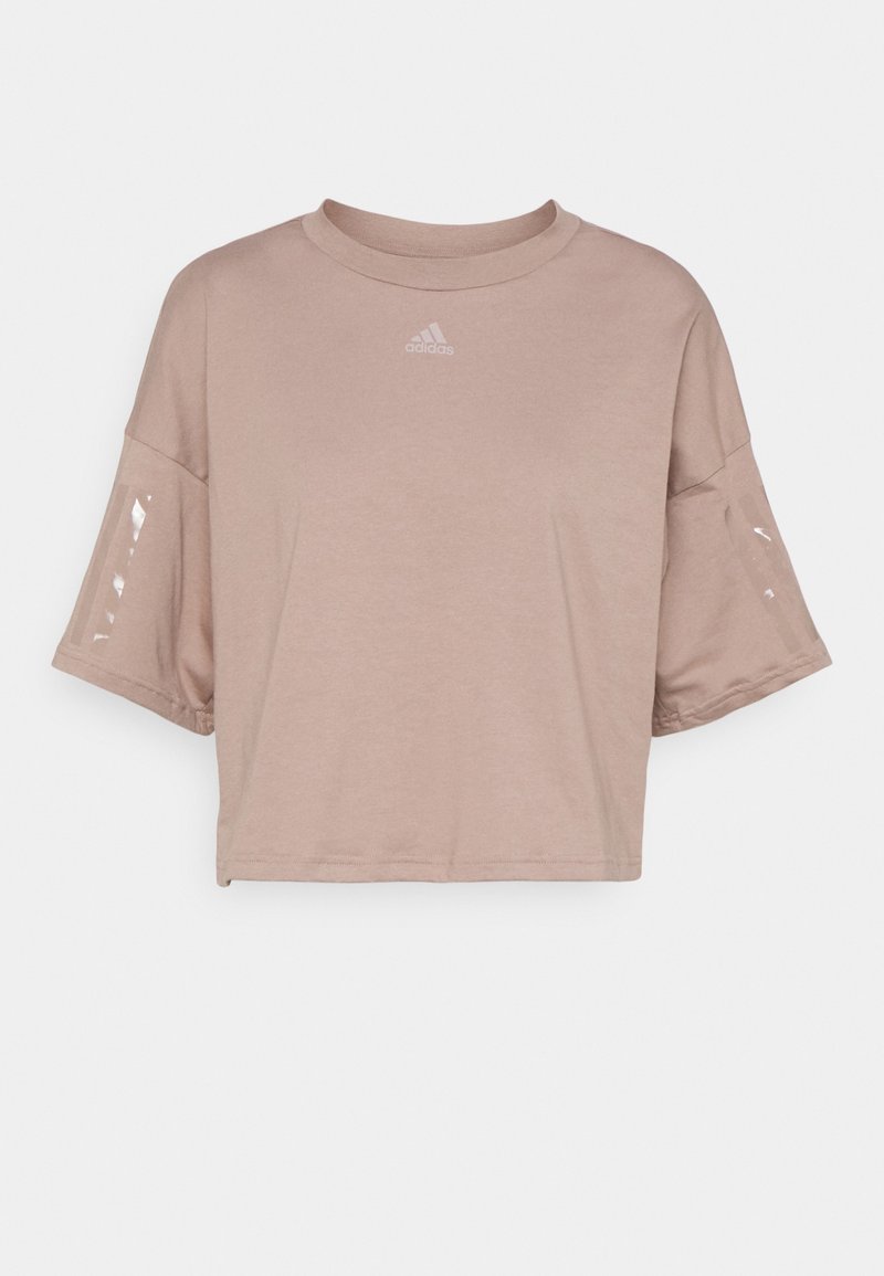 Kortärmad, cropped t-shirt i ljusbeige. Tillverkad av mjukt tyg med rund halsringning, prydd med en liten logotyp och tydliga detaljer på ärmarna.