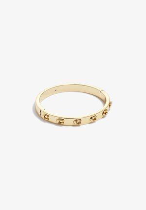 Pulsera de oro tipo bangle con una superficie lisa y reflectante que presenta acentos decorativos. Forma circular con un cierre de bisagra sutil.