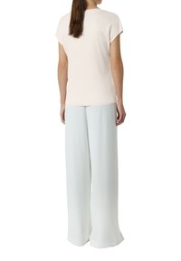 Lichtroze T-shirt met korte mouwen en een ronde halslijn, gecombineerd met losse, vloeiende lichtblauwe wijde broekspijpen. Glad textuur, casual ontwerp.