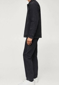 Chaqueta y pantalones de mezclilla negra, diseño ajustado, puños en las muñecas y detalles en los bolsillos, combinados con zapatillas blancas. Textura suave, estilo casual.