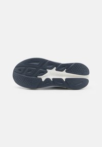 Donkerblauwe rubberen sneakerzool met getextureerde patronen, voorzien van groeven en een witte tussenzool voor grip en duurzaamheid.