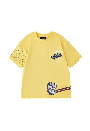 Maglietta gialla a maniche corte con manica sinistra nera a motivi, scritta "Viva la Siesta", piedi illustrati e tre Z sulla parte frontale.