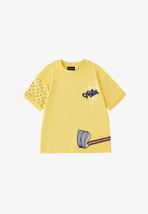 Maglietta gialla a maniche corte con manica sinistra nera a motivi, scritta "Viva la Siesta", piedi illustrati e tre Z sulla parte frontale.