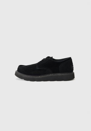 Zwarte suède veterschoenen met een ronde neus, contrasterende stiksels en een dikke rubberen zool, met een merkdetail op de hak.