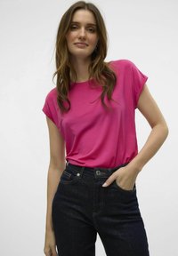 Fuchsia korte mouwen t-shirt met een ronde hals, gecombineerd met hoge taille donkerdenim jeans, voorzien van standaard zakken en een knoopsluiting.