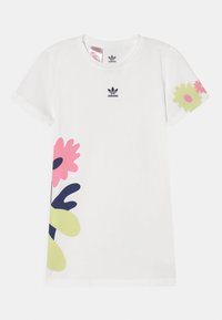 Vit kortärmad t-shirt med en färgglad blommönster i rosa, grönt och marinblått på vänster sida, med en Adidas-logga på bröstet.
