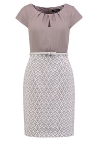 Kjolen har en lavendel top med læg, korte ærmer og en tætsiddende hvid nederdel med et gentaget bladmønster, strammet med et tyndt bælte.