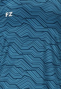 Blått tyg med mörkblå geometriska zickzackmönster och vit "FZ"-logotyp i det övre vänstra hörnet.