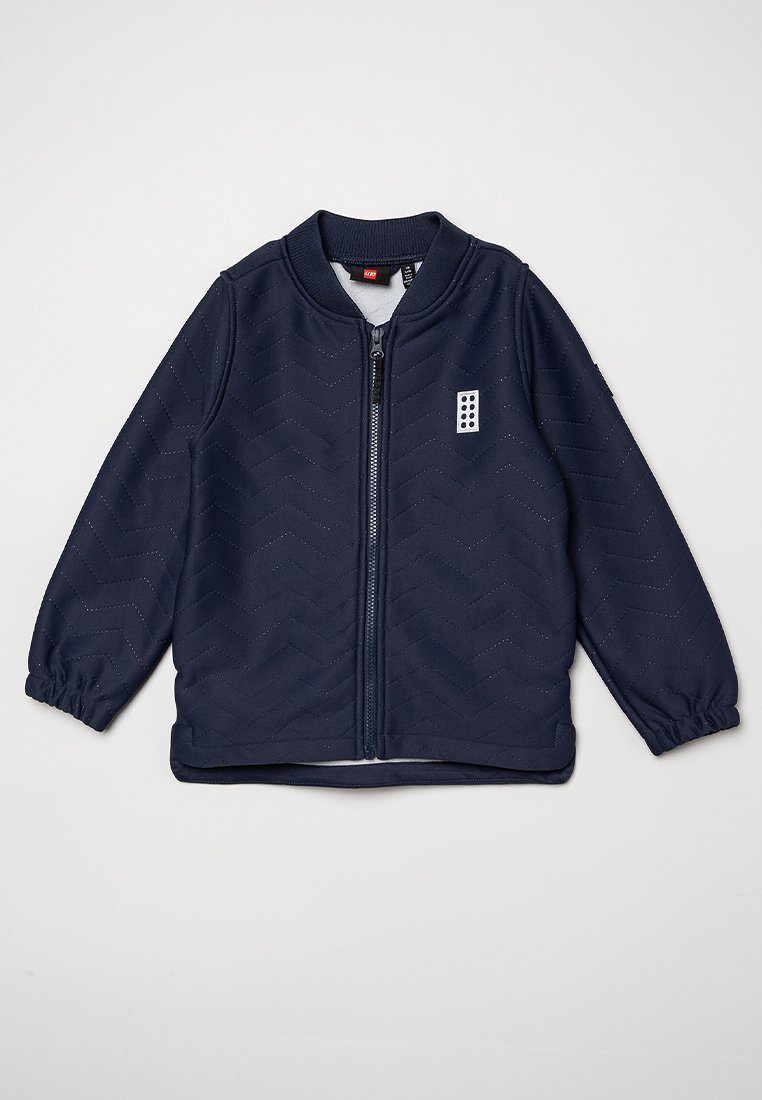 Giacca blu navy con motivo a chevron, chiusura zip frontale, colletto a costine e polsini elasticizzati. Presenta una piccola grafica sul petto.