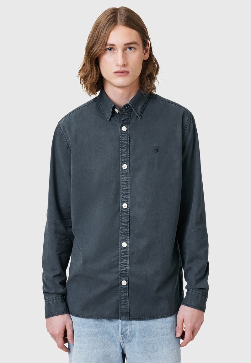Maglietta a maniche lunghe grigio scuro in cotone, con colletto button-down, bottoni frontali e logo discreto sul petto.