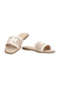 Sandalias tipo slide de dedo abiertas, hechas de material trenzado en color beige, con una tira crema que muestra un logotipo. Suelas planas con un acabado de goma en marrón claro.