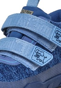 Scarpe in tessuto blu con parte superiore testurizzata, due cinturini in velcro e suola in gomma. Presentano un piccolo logo di elefante sul cinturino.