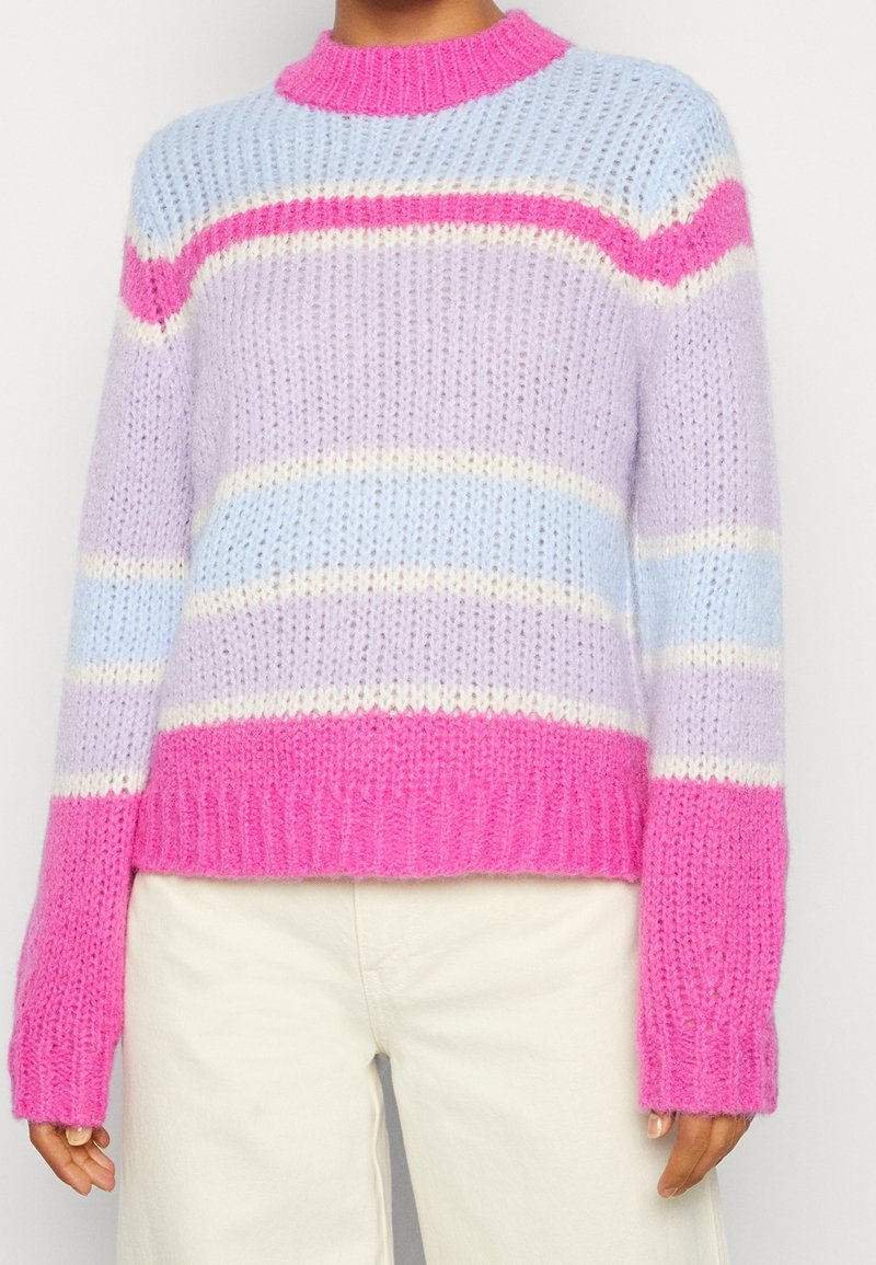 Stickad tröja i pastellfärger: ljuslila, rosa och blå ränder, med en ribbad rosa krage och mudd. Mjuk, texturerad tyg.