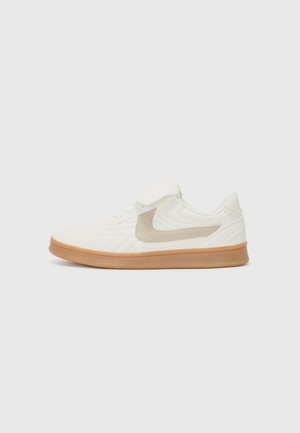 Baskets blanches de sport avec un dessus texturé, accent en suède beige et semelle en caoutchouc beige. Présente un design à lacets et un col rembourré.