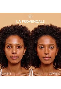 Portraits avant et après d'une personne aux cheveux foncés et bouclés. Le ton de peau semble plus lisse et plus uniforme sur l'image après. L'arrière-plan est beige.