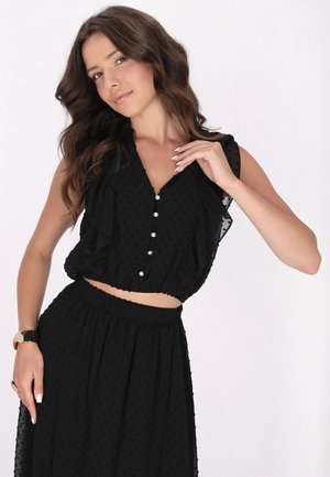 Schwarzes Crop-Top und Rock-Set aus strukturierter Stoff mit kleinen Punkten, mit Rüschensleeves und einer Knopfleiste. Weiches, fließendes Design.