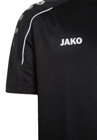 Schwarzes Sporttrikot aus strukturiertem Stoff. Verfügt über das weiße Logo "JAKO" und Akzente, mit Rundhalsausschnitt und kurzen Ärmeln.