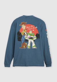 Langarm-Blaue Baumwoll-T-Shirt mit den Cartoon-Charakteren Woody und Buzz Lightyear auf der Rückseite, mit einem roten Kreis und Text.