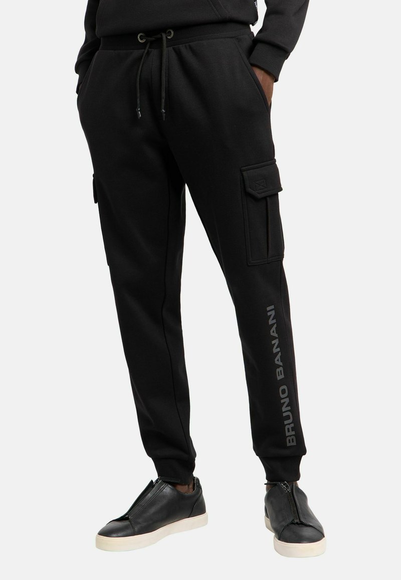 Zwarte joggingsbroek van zachte stof, met een trekkoord in de taille, zijzakken en een logo-detail op het linkerbeen.