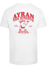 T-shirt en coton blanc avec un graphisme imprimé rouge représentant un personnage de boisson au yaourt, texte "AYRAN THE STREETS" et détails sur la boisson.