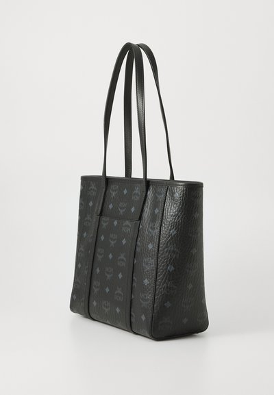 Melna ādas tote soma ar teksturētu virsmu, kas rotāta ar MCM logotipu smalkā rakstā un divām rokturiem ērtai nēsāšanai.