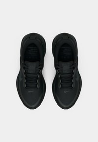 Un paio di scarpe da corsa nere sportive con lacci, logo Nike sulla punta e sui lati, viste dall'alto su uno sfondo bianco.
