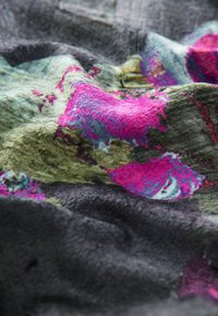 Textília s míšaným farebným vzorom s živými odtieňmi ružovej, zelenej a modrej. Mäkká textura s plush, vrstveným vzhľadom.