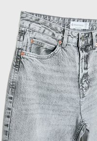 Jean en denim gris clair acid-wash avec rivets en cuivre, poches avant, passants pour ceinture, fermeture par boutons et étiquette Stradivarius taille 38.