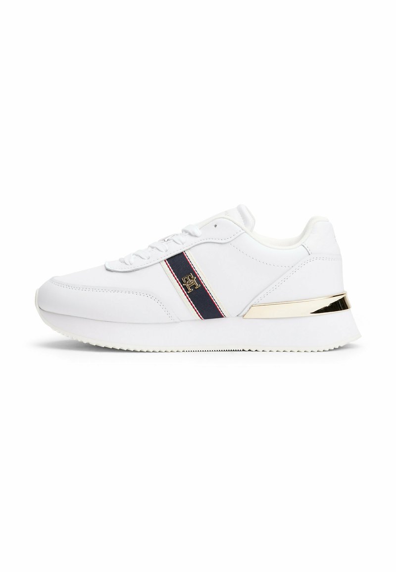 Sneaker bianca realizzata in materiale sintetico, con una striscia blu e dettagli in oro sulla parte posteriore. Design con lacci, suola testurizzata.