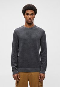 Ciemnoszara swetrowa bluza z długimi rękawami i okrągłym dekoltem. Posiada prążkowane mankiety i dół, co dodaje tekstury.