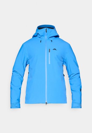 Svetlo modra nepremočljiva jakna z kapuco, sprednjim zadrgo in dvema stranskima žepoma. Gladka tekstura z črnim logotipom na prsih.