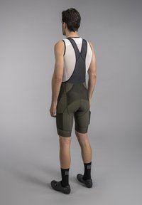 Men's cycling bib shorts in olive green with adjustable black straps, a fitted design, and contrasting mesh material on the upper back.