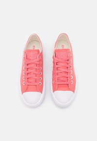 Vaaleanpunaiset kangaskengät, joissa on valkoiset kumipohjat, pyöreä kärki ja samaa sävyä olevat nauhat. Kengissä on teksturoitu pinta ja brändilogo kielessä.