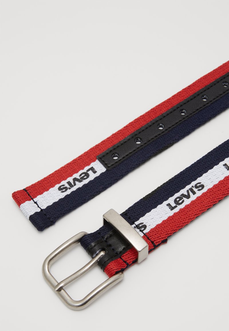 Stoffgürtel mit roten, marineblauen und weißen Streifen; silberne Metallschnalle; Lederunterlage mit verstellbaren Löchern; auf der Vorderseite mit "Levi's" gebrandet.