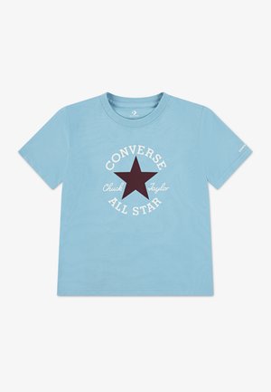 Helehall sinine puuvillast t-särk, millel on tumepunane tähegraafika ja selle ümber valge "Converse Chuck Taylor All Star" tekst. Klassikalise ümara kaelusega disain.