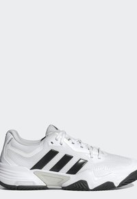 Biele tenisky Adidas s čiernymi pruhmi, textúrovanou podrážkou a bielymi šnúrkami zobrazené v bočnom profile na svetlom pozadí.