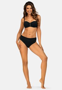 Czarny zestaw bikini z bandeau, wyposażony w złoty zapięcie na środku oraz pasujące wysokie majtki, wykonany z gładkiego, elastycznego materiału.