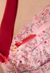 Roza torbica z vzorcem cvetlic, rdečim nastavljivim trakom, z zlatim zadrgo in tkanino z rožami, srcami in risanimi liki.