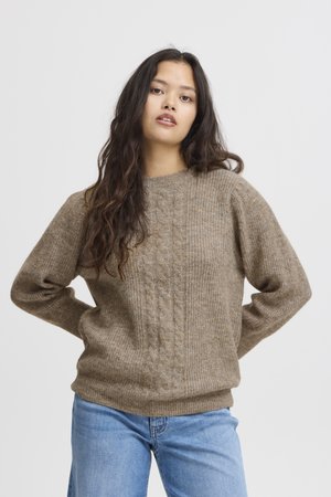 Maglione in lana intrecciata marrone con scollo rotondo e fondo a coste, abbinato a jeans blu. Morbido al tatto con maniche lunghe e leggermente a sbuffo.