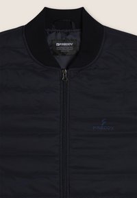 Giacca puffer navy con chiusura a zip, colletto a coste, texture a righe orizzontali e un logo sottile sul petto. Design leggero e sportivo.