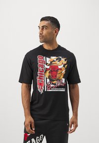 Schwarzes T-Shirt mit einem großen Grafikmotiv eines roten Bullenkopfes mit Flammen, dem Text "Chicago" und einem Basketball-Design. Kurze Ärmel, Rundhalsausschnitt.