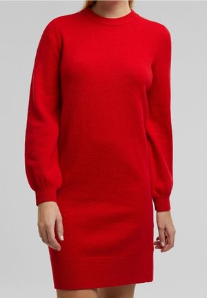 Czerwona, długorękawowa sukienka sweterkowa z okrągłym dekoltem i ściągaczami na rękawach, pokazana na osobie od szyi do połowy uda na jednolitym tle.