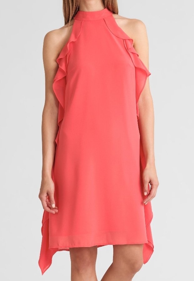 Robe corail sans manches avec col halter et côtés à volants, tombant au-dessus des genoux sur une personne debout.