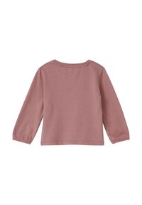 Lange mouwtop van gedempt roze stof. Ronde halslijn, zachte textuur, elastische manchetten en een eenvoudig ontwerp zonder versieringen.