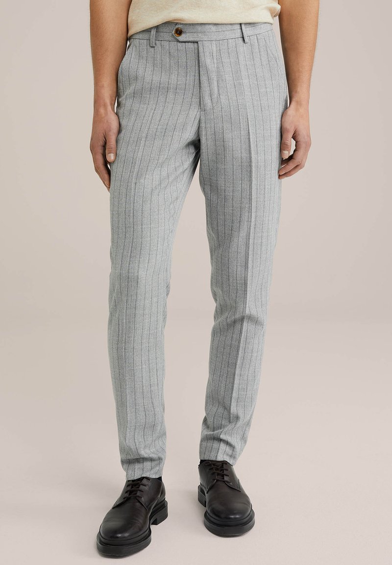 Pelēki pinstrīpa bikses, izgatavotas no teksturēta auduma, ar pogu aizdari, sašaurinātiem galiem un sānu kabatām. Kombinētas ar melnām apaviem.