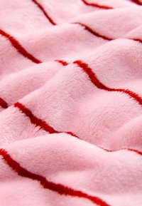 Pink plush fabric with a soft texture, featuring wavy red stripes running across the surface. Smooth and inviting appearance.