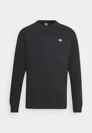 Black crewneck sweatshirt made of soft fabric, featuring long sleeves and a small logo on the chest. Plain design with ribbed cuffs.