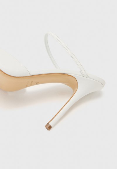 Bílé sandály na vysokém podpatku s elegantním designem, hladkým koženým svrškem, tenkým páskem a špičatou špičkou. Podpatek je elegantně zakřivený a štíhlý.